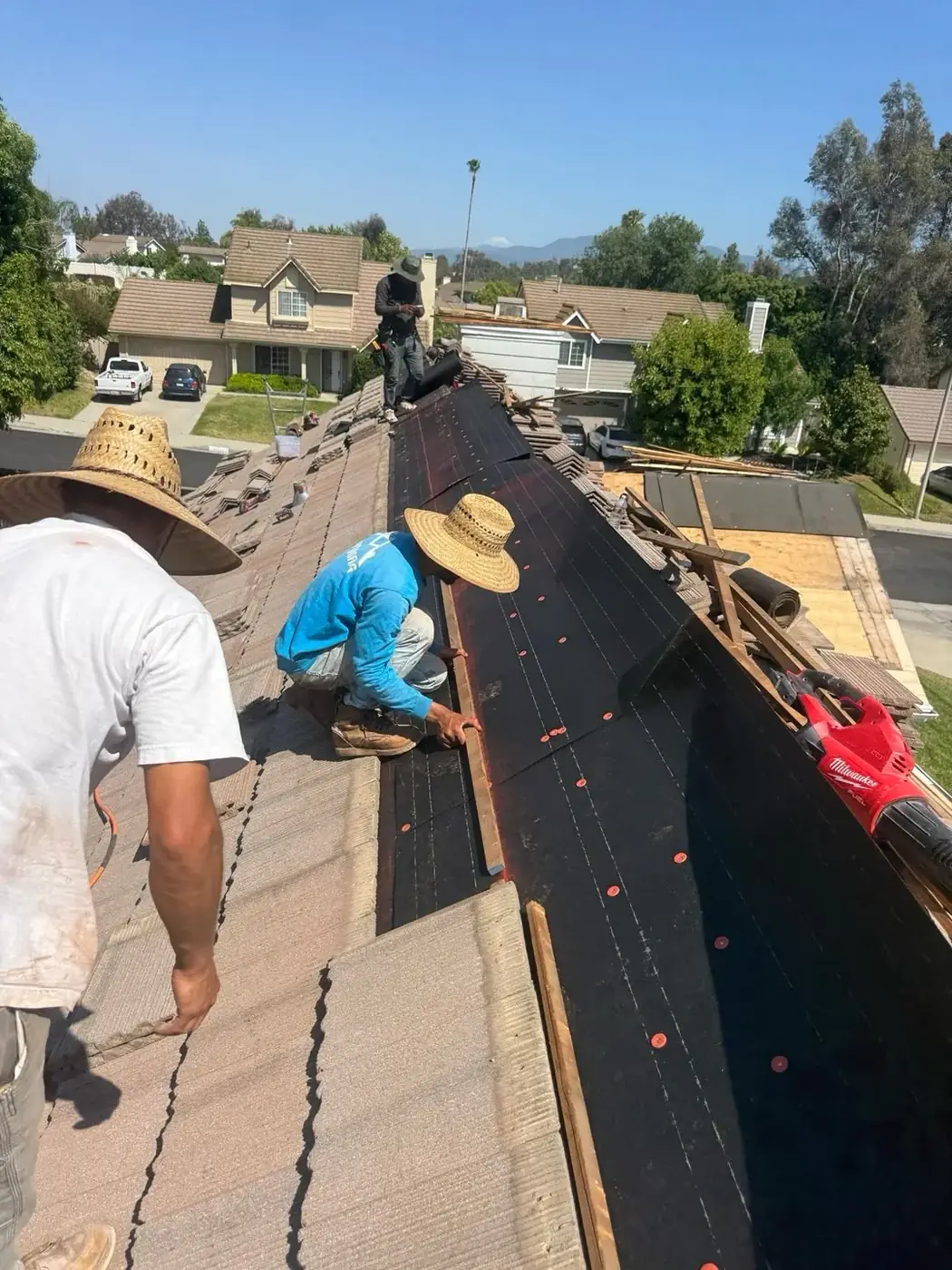 Roofer installing new underlayment on a Murrieta, CA tile roof